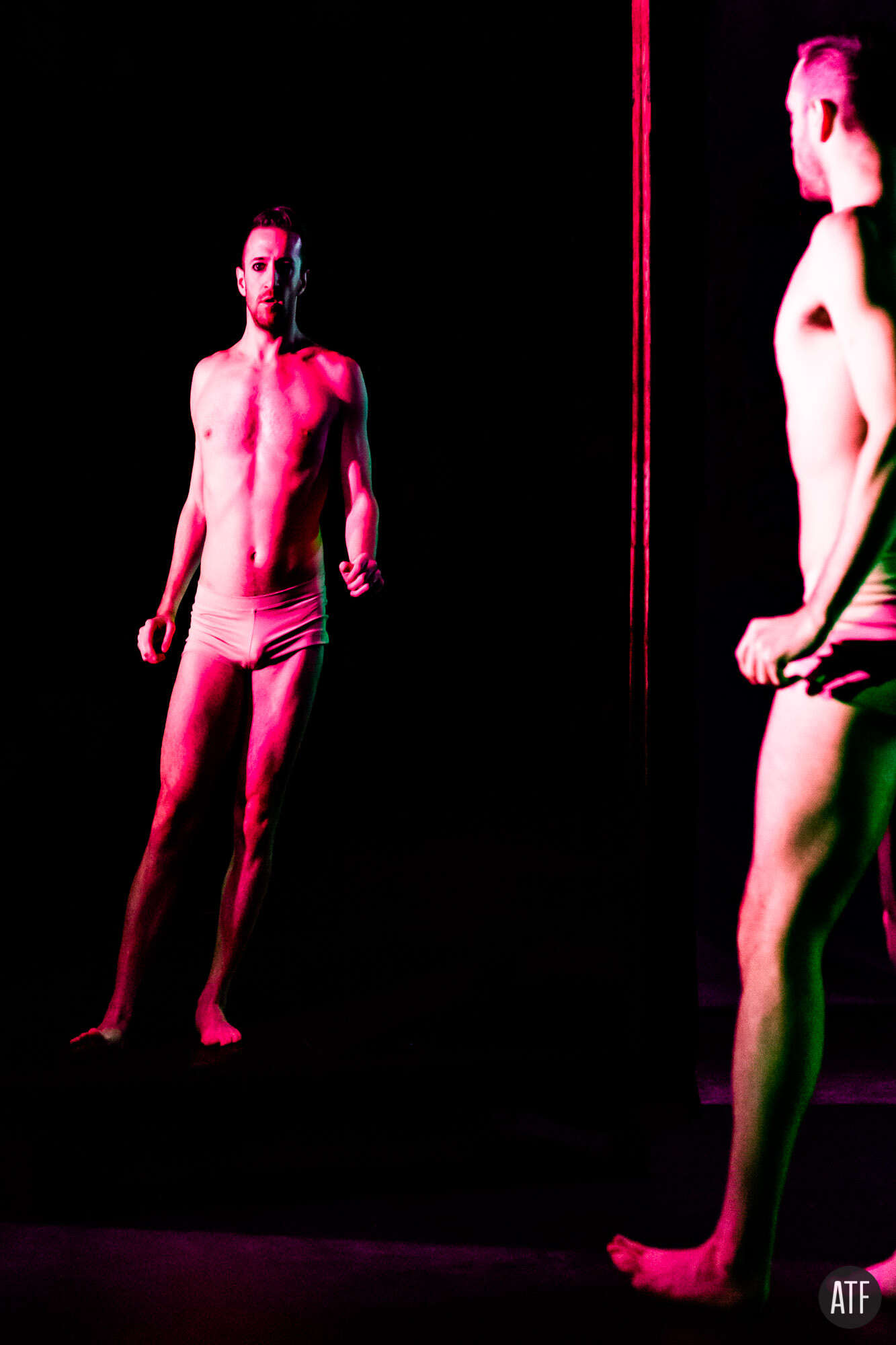 Performers in red-pink light