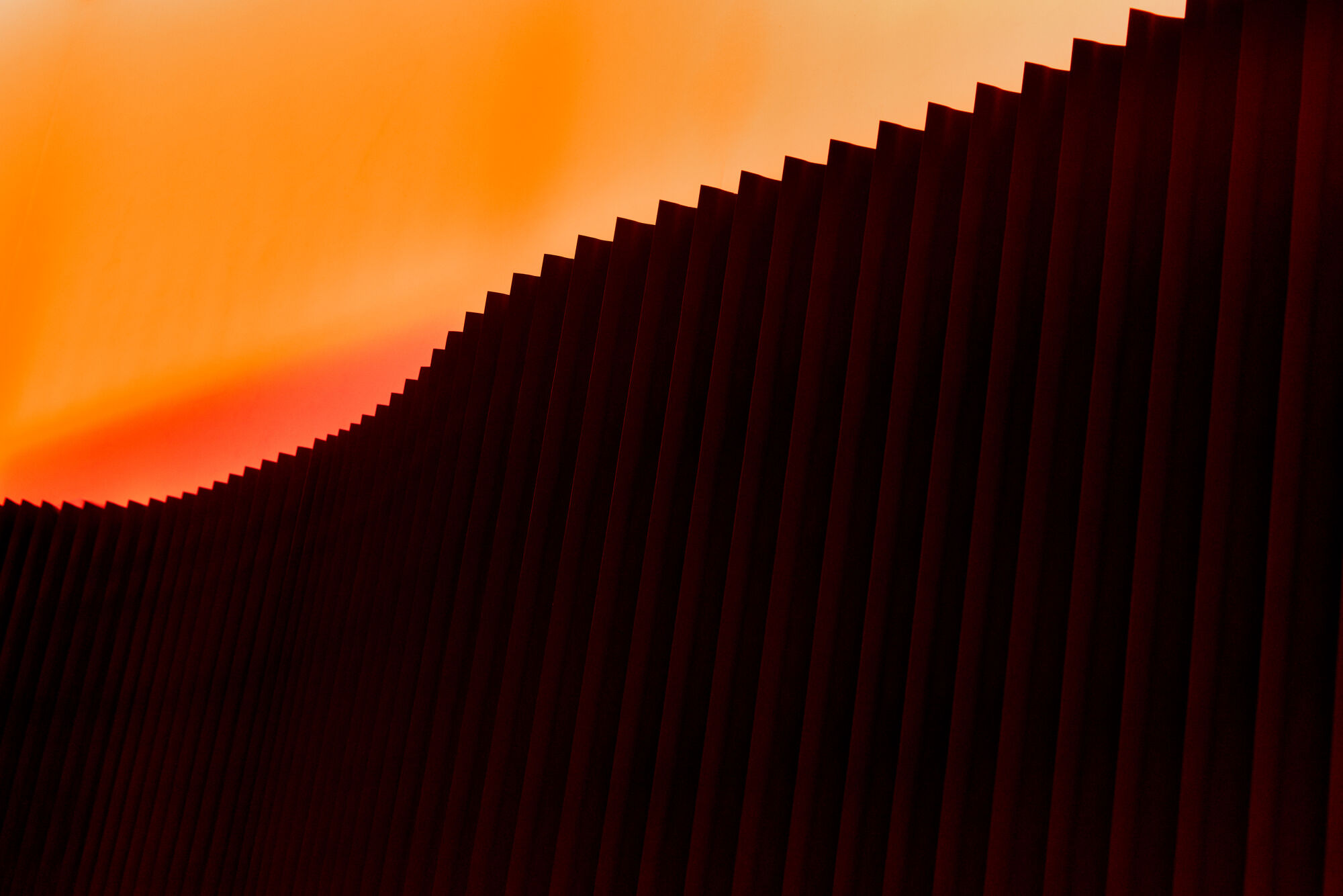 Detail — ribbed wall panels with amber cove light washing overhead