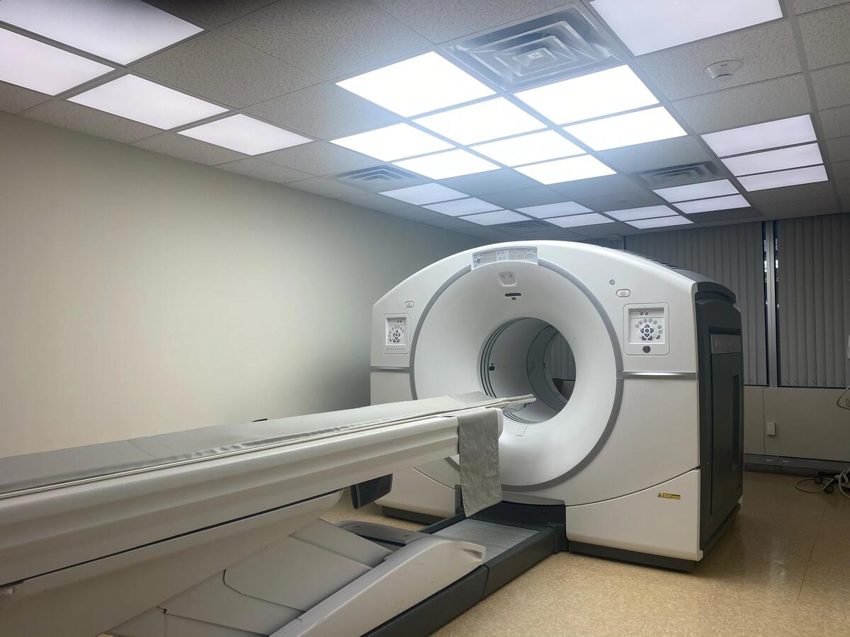 PET/CT scanner room before renovation — clinical beige walls, drop ceiling